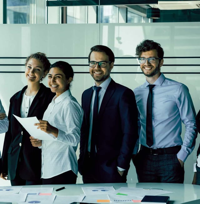 A group of smiling people in a conference room.