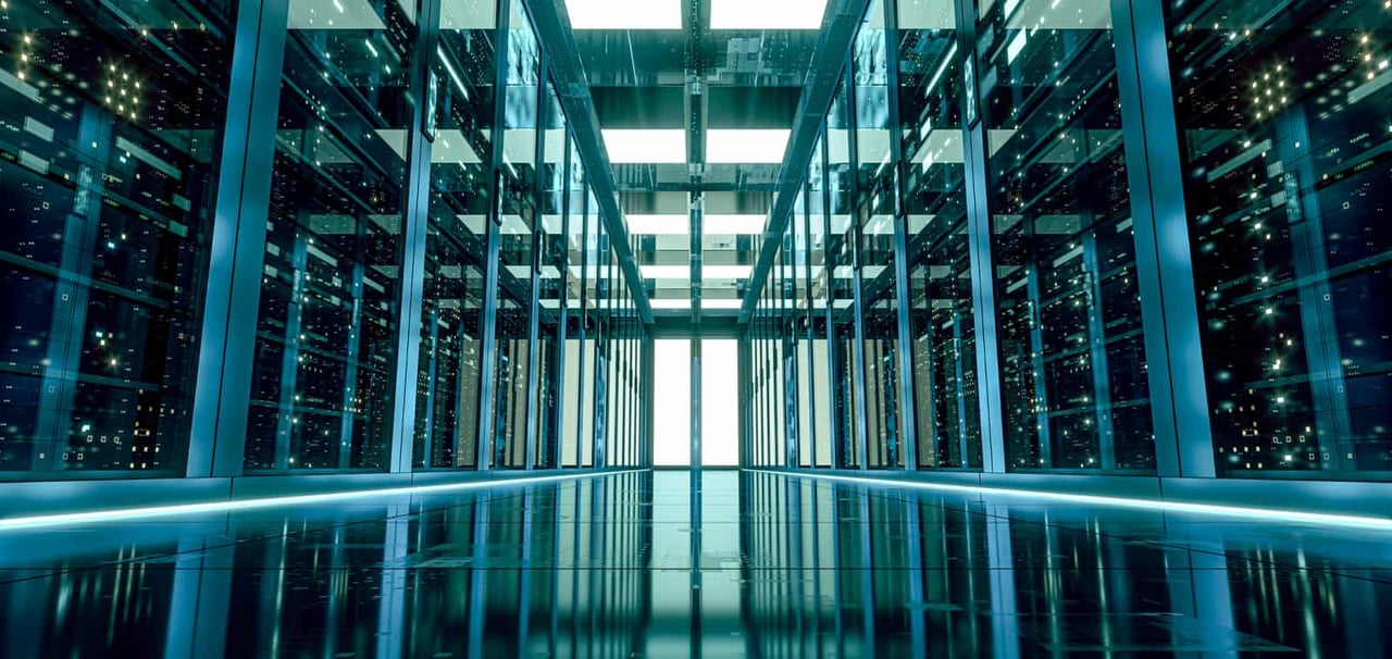 An aisle between two rows of servers in glass cabinets.