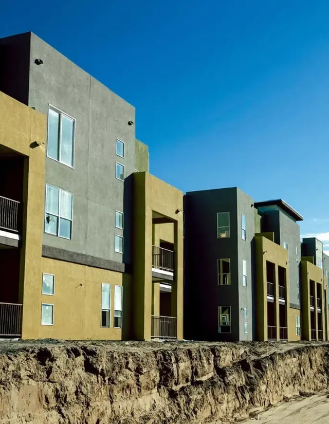 A partially-constructed apartment complex next to an excavation area